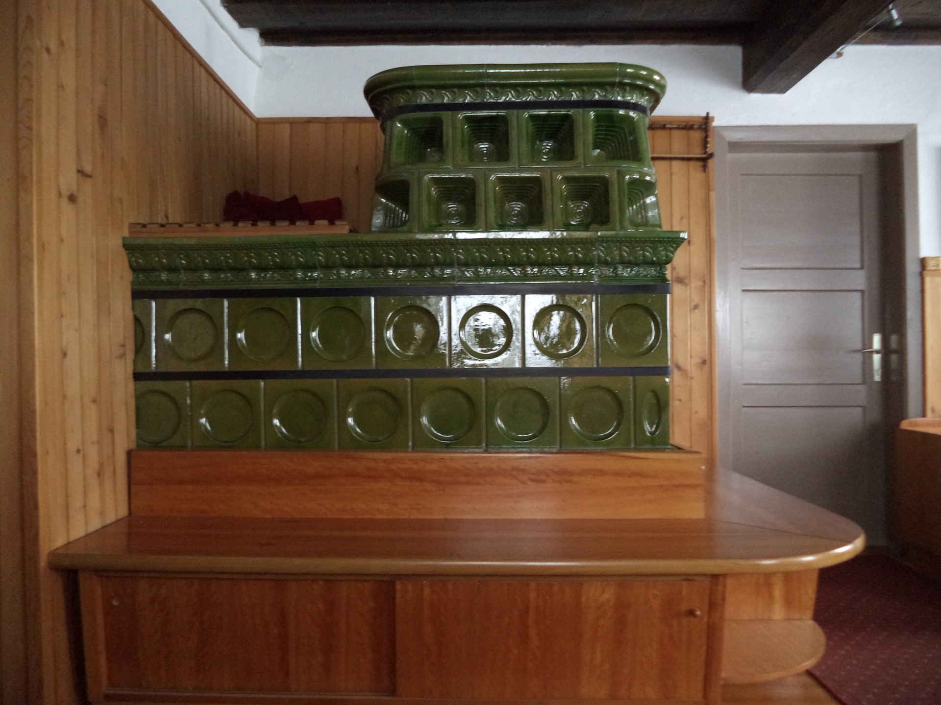 The living room has a large stove that warms the house during cold winters.